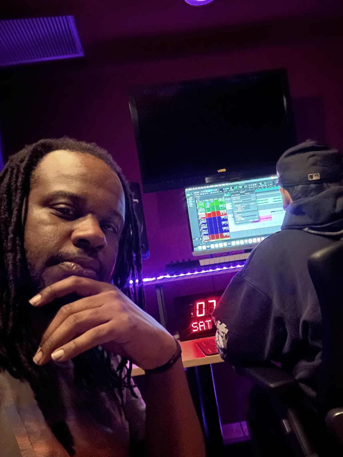 MT The Great at the studio desk with a session open on screen, purple lighting